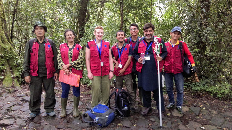 RBG Kew staff and training course participants stood holding seed collecting equipment and smiling in a forest